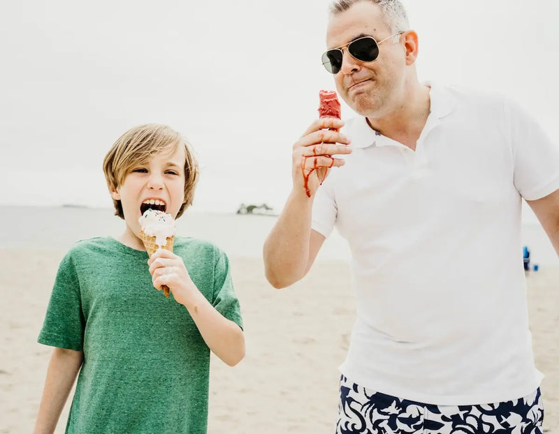 Father and son on beach with icecream.